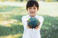 Young asian boy holding planet Earth globe at natural park background. Gyre Royalty Free Stock Photo