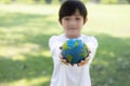 Young asian boy holding planet Earth globe at natural park background. Gyre Royalty Free Stock Photo