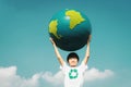 Young asian boy holding planet Earth globe at natural park background. Gyre Royalty Free Stock Photo