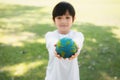 Young asian boy holding planet Earth globe at natural park background. Gyre Royalty Free Stock Photo