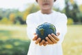 Young asian boy holding planet Earth globe at natural park background. Gyre Royalty Free Stock Photo