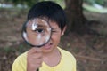 Young asian boy looking through magnifying glass Royalty Free Stock Photo