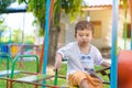 Young Asian boy play a iron train swinging at the playground under the sunlight in summer. Royalty Free Stock Photo