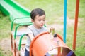 Young Asian boy play a iron train swinging at the playground under the sunlight in summer. Royalty Free Stock Photo