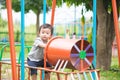 Young Asian boy play a iron train swinging at the playground under the sunlight in summer. Royalty Free Stock Photo
