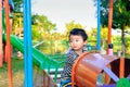 Young Asian boy play a iron train swinging at the playground under the sunlight in summer. Royalty Free Stock Photo