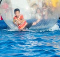 Young Asian boy playing inside a floating water walking ball Royalty Free Stock Photo