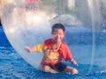 Young Asian boy playing inside a floating water walking ball Royalty Free Stock Photo