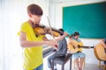 Young boy playing violin in classroom