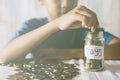 Young asian boy putting coins into glass jar.