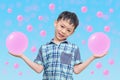 Young Asian boy showing pink bubbles