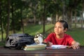 Young asian boy studying at park while looking at empty space