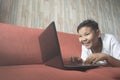 Young asian boy using laptop computer on a sofa at home. Royalty Free Stock Photo