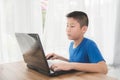 Young Asian boy using laptop technology at home. Royalty Free Stock Photo