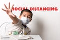 Young Asian boy wearing a face mask putting his hand out as if signalling to say stay away / keep your distance and text Royalty Free Stock Photo