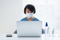 Young Asian boy wearing face mask working on laptop Royalty Free Stock Photo