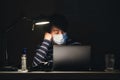 Young Asian boy wearing face mask working late at night Royalty Free Stock Photo