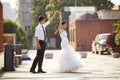 Asian bride and groom dancing in parking lot Royalty Free Stock Photo