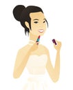 Young asian bride paints lips with red lipstick. Royalty Free Stock Photo