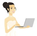 Young asian bride in a white dress using a laptop.