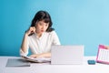 Young asian buisness woman working on blue background