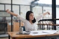 Young Asian Business Accountant woman stretching herself and relax while working hard. Royalty Free Stock Photo