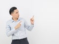 Young asian business man with blue shirt pointing to the side with a hand to present a product or an idea isolated on white Royalty Free Stock Photo