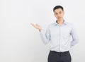 Young asian business man with blue shirt pointing to the side with a hand to present a product or an idea isolated on white Royalty Free Stock Photo