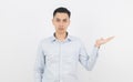 Young asian business man with blue shirt pointing to the side with a hand to present a product or an idea isolated on white Royalty Free Stock Photo