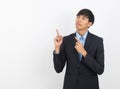 Young asian business man with blue shirt pointing to the side with a hand to present a product or an idea isolated on white Royalty Free Stock Photo