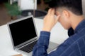 Young asian business man headache during working on laptop computer display blank screen with deadline at home. Royalty Free Stock Photo