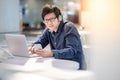 Young Asian business man listening to music while working with l Royalty Free Stock Photo