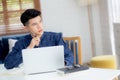 Young asian business man planning working and using laptop computer on desk at home, notes about finance, male study and learning Royalty Free Stock Photo