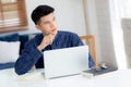 Young asian business man planning working and using laptop computer on desk at home. Royalty Free Stock Photo