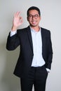 Young Asian business man smiling happy while giving OK finger sign