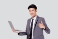 Young asian business man standing work on laptop computer to internet online isolated on white background. Royalty Free Stock Photo