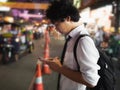 Young Asian business man using mobile smart phone in the street at night. Social and internet of thing concept Royalty Free Stock Photo