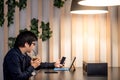 Young Asian business man using smartphone and tablet in cafe Royalty Free Stock Photo