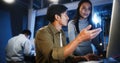 Young Asian business man and woman work late night together on desktop computer with team in home office Royalty Free Stock Photo