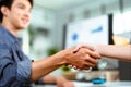Young Asian business people shaking hands Royalty Free Stock Photo