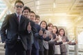 The young Asian business team stands with confidence and pride.They raise their thumbs at the same time. Royalty Free Stock Photo