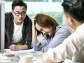 Young asian business woman appearing to be frustrated during a discussion in office