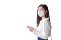 Young Asian business woman is going to the office or workplace which she look at camera while wearing mask holds smartphone in her Royalty Free Stock Photo