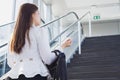 Young Asian business woman going to work by walking on the stairs and holding her bag. Business and finance concept