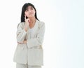 A young asian business woman has a big smile and place a finger close to her cheek, looking up to the side on copy space white Royalty Free Stock Photo