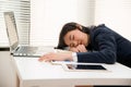 Young Asian business woman lying down on the desk in office because tired overworked. Royalty Free Stock Photo