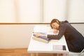 Young Asian business woman lying down on the desk in office because tired overworked. Royalty Free Stock Photo