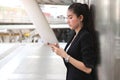 Young Asian business woman with mobile smart phone in urban background. Internet of things concept Royalty Free Stock Photo