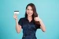 Young Asian business woman showing like thumb up and credit card for making payment or paying online business isolated on blue Royalty Free Stock Photo