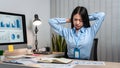 Young Asian Business woman sitting on the chair stretching herself and exercise for relaxation while working hard at office Royalty Free Stock Photo